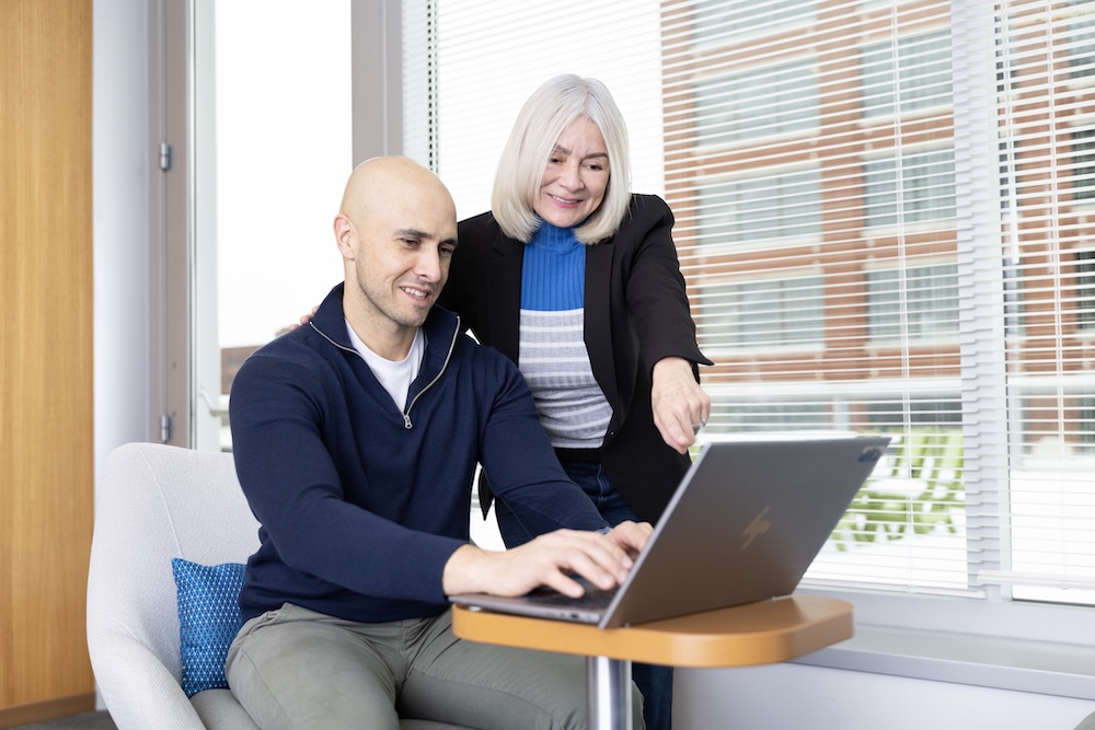 Julio, transplant recipient (left) with NMDP Patient navigator, Erica Julio, transplant recipient, working on a laptop with NMDP Patient navigator Erica